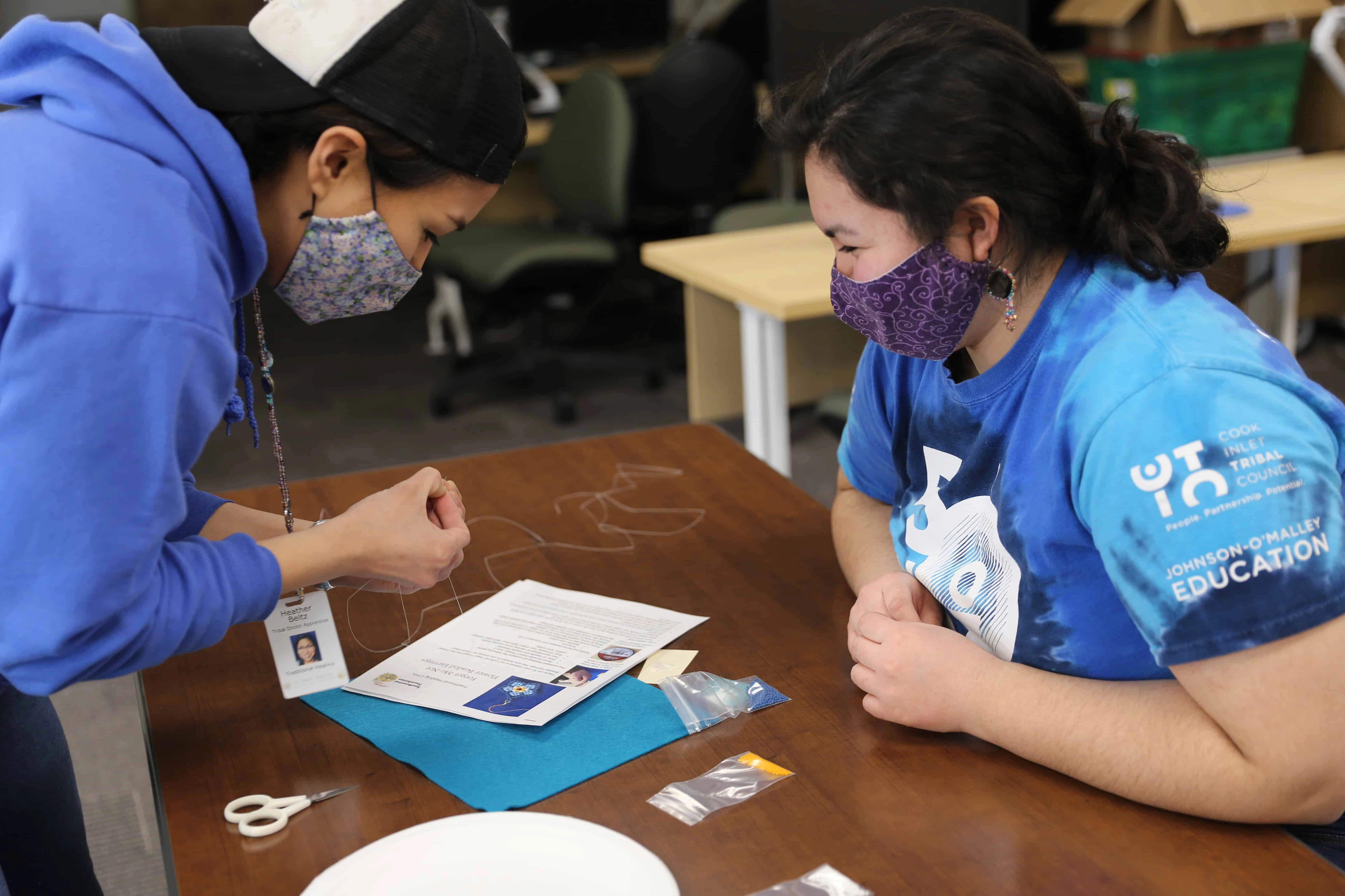RAISE youth program interns displaying their handcrafted beaded projects